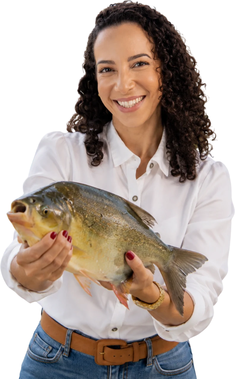 Soraia Dall'Agnol sorri enquanto segura um peixe com as duas mãos