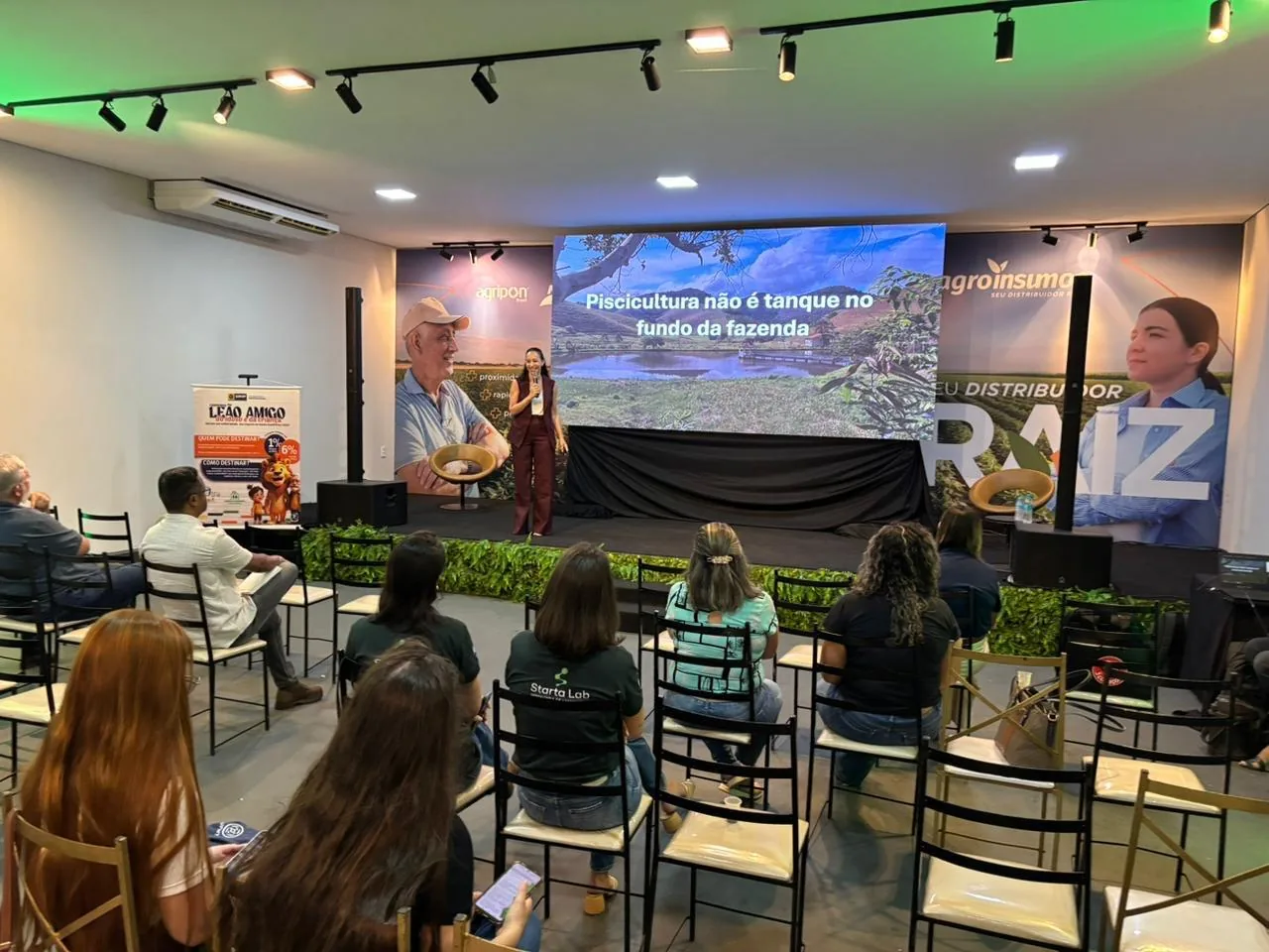 Soraia no palco; no telão, a frase “Piscicultura não é tanque no fundo da fazenda”